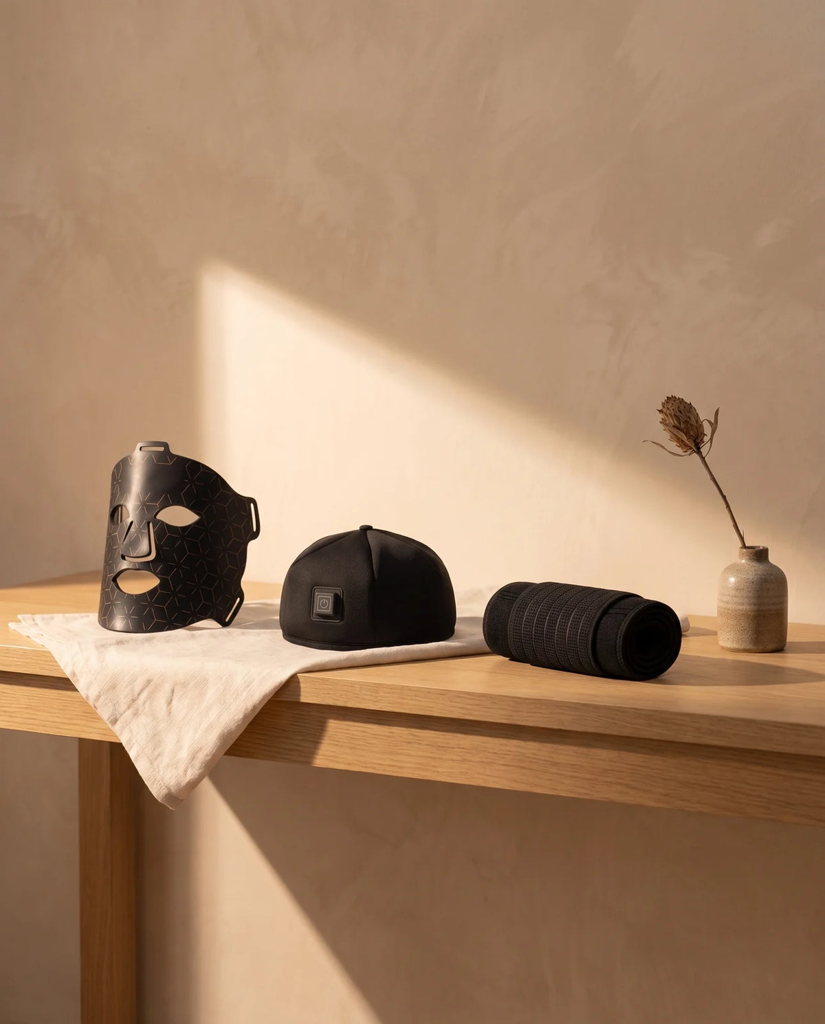Clinirae Light Mask, Scalp Light Cap and Light Wrap on an oak console