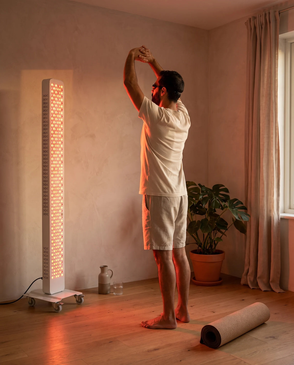 Man stretching in front of the Clinirae Light Panel 320 at home