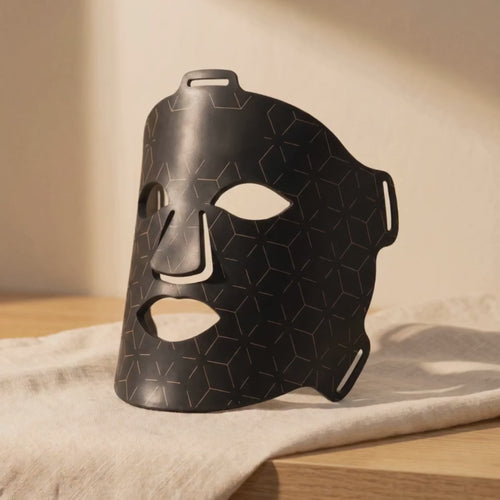 Clinirae Light Mask LEDs glowing warm red on cream linen